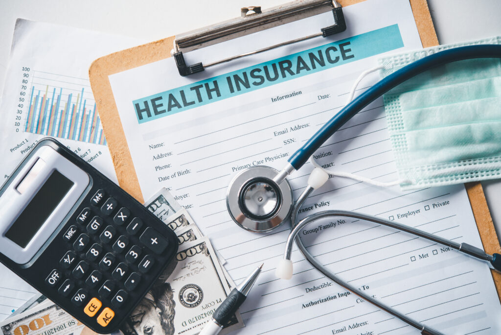 Stethoscope and calculator placed on health insurance documents,
