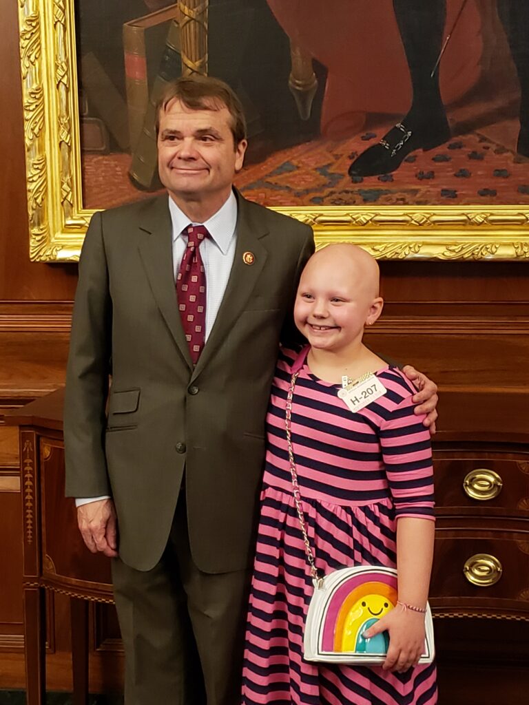 Girl with alopecia areata standing with government official